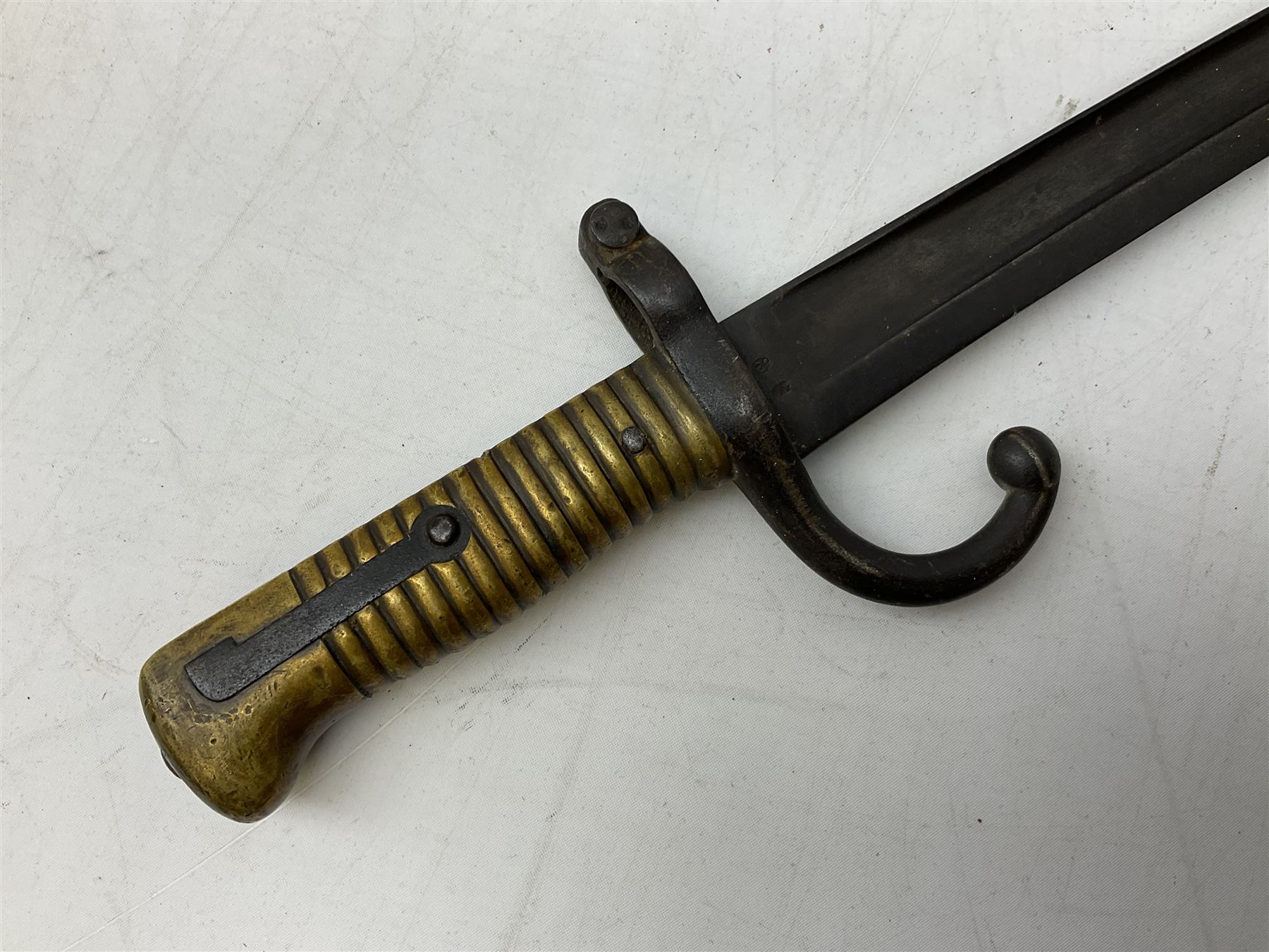 French Model 1866 sabre bayonet with 57cm fullered steel curving blade; in steel scabbard L71cm overall; another Model 1866 sabre bayonet lacking scabbard; and British Pattern 1856 sword bayonet (no scabbard) (3)