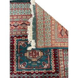 Persian red and green ground runner, the field decorated with seven square panels, five band border decorated with stylised motifs