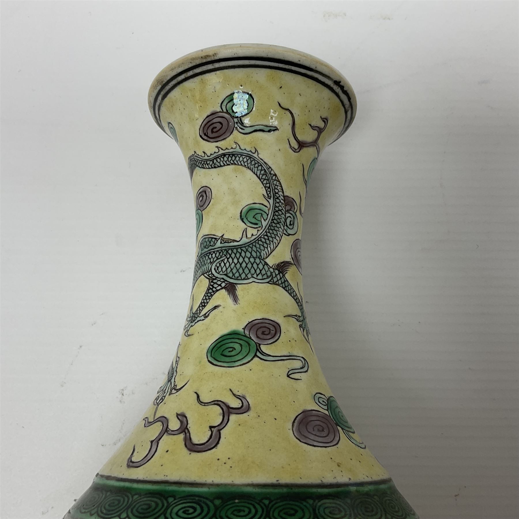 20th century Chinese Famille Verte vase, of slender ovoid form with tapering neck and flared rim, decorated with green and grey enamel with dragons chasing flaming pearls amongst auspicious clouds upon a yellow ground, H30cm