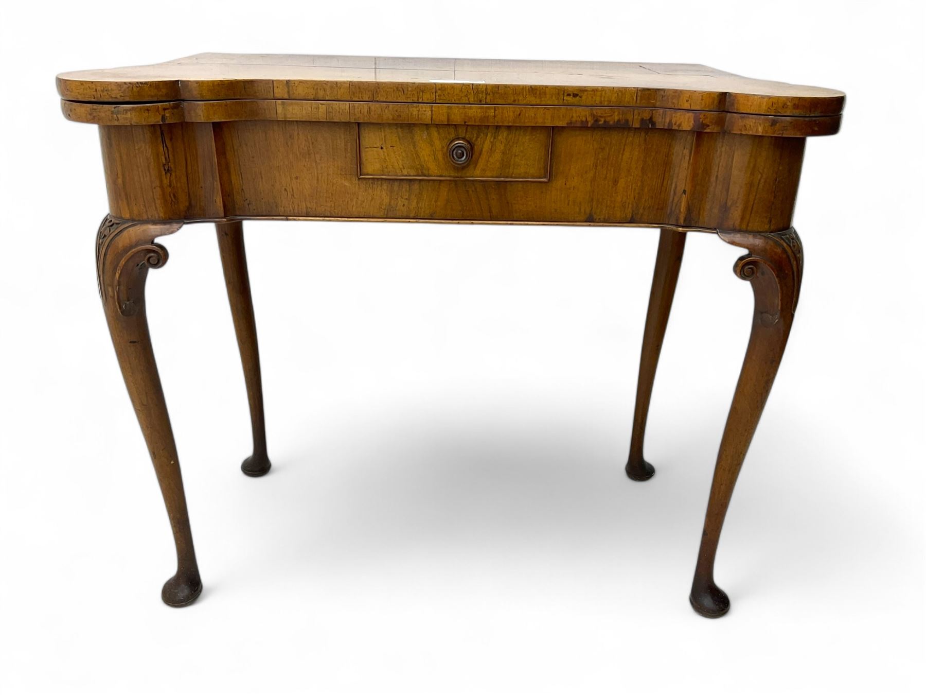 Georgian walnut fold-over card table, shaped rectangular top opening to reveal a baize-lined surface, supported by a concertina pull-out rear mechanism, frieze fitted with single drawer, raised on cabriole supports with foliate carvings terminating in pad feet