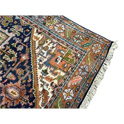 Persian Heriz indigo and rust ground rug, central geometric star medallion decorated with stylised foliate motifs, the border decorated with stylised flower heads