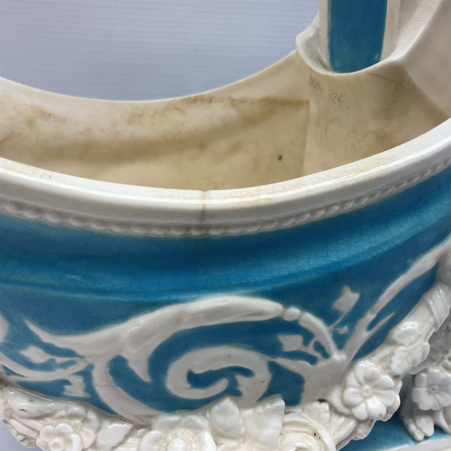 Rare 19th century Minton turquoise glaze majolica 'The Reader' flower holder, after Albert Carrier-Belleuse, modeled as a maiden in classical drapery reading whilst leaning against the pillar back of the helmet shaped cistern detailed with a caryatid and floral swags, the whole upon an oval plinth with Greek key border, with impressed marks beneath, H44cm