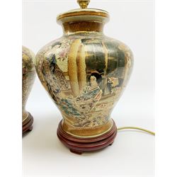 A pair of 20th century Japanese Satsuma style table lamps, decorated with figural scenes and heightened with gilt, each upon wooden base, overall H39cm. 