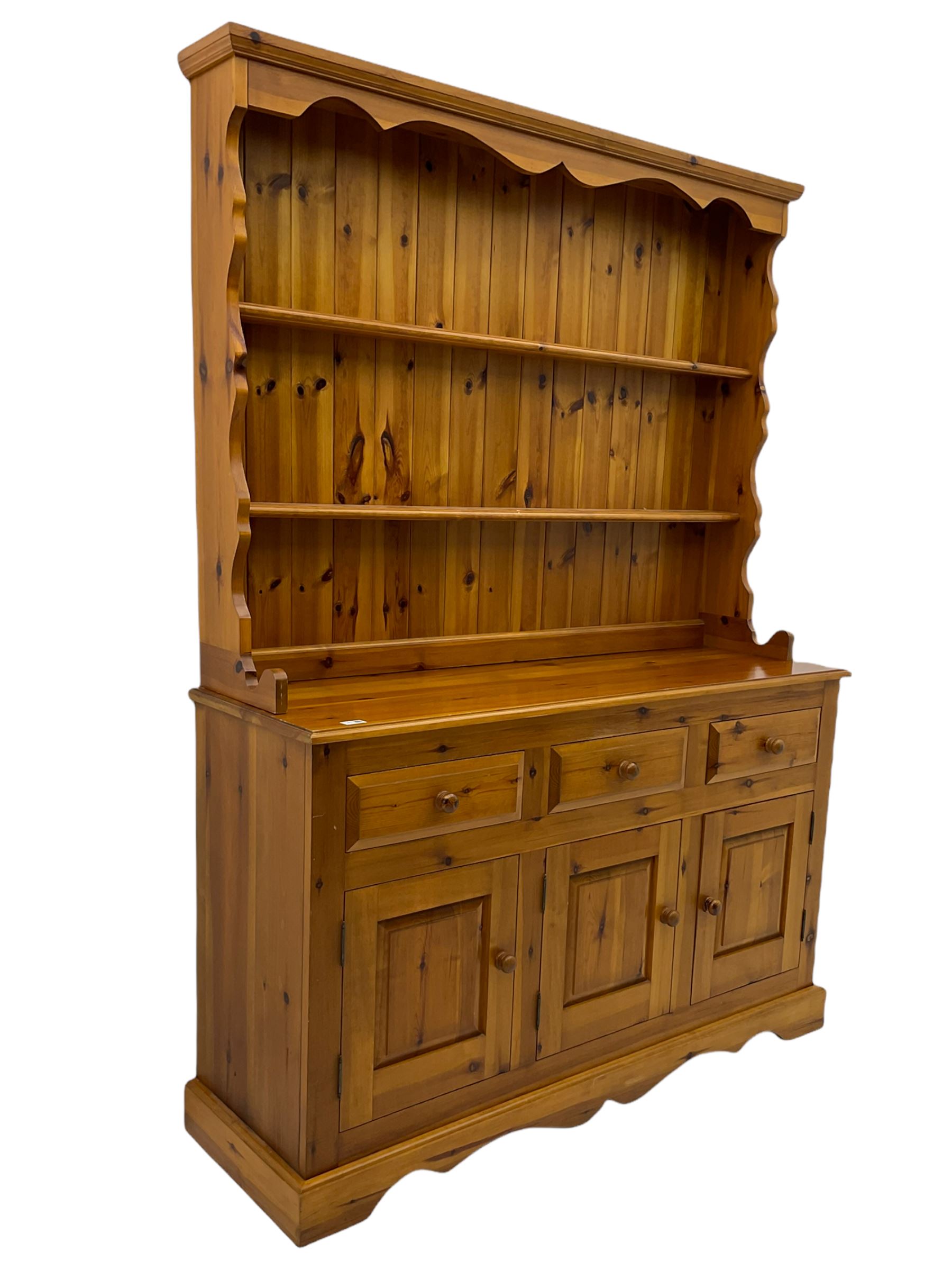 Pine farmhouse dresser with three drawers and three cupboards, and two tier plate rack