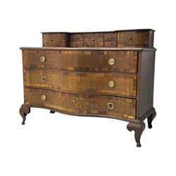 Late 19th century continental oak commode, serpentine fronted with parquetry and crossbanded decoration, the raised superstructure back fitted with a central bank of five recessed drawers flanked by concave drawers, above three full-width drawers with brass ring handles, raised on cabriole supports