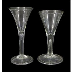 Two 18th century drinking glasses, the drawn trumpet bowls upon stems with internal tears, one elongated, and folded conical feet, largest H18cm