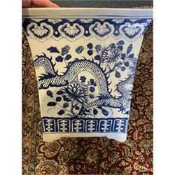 Chinese blue and white planter and stand, each of square slightly tapering and flared form, the planter decorated with two dragons and blossoming peonies, between stylised borders, the stand decorated with flower heads and vines, planter H30cm W29cm, stand H7cm D28.5cm