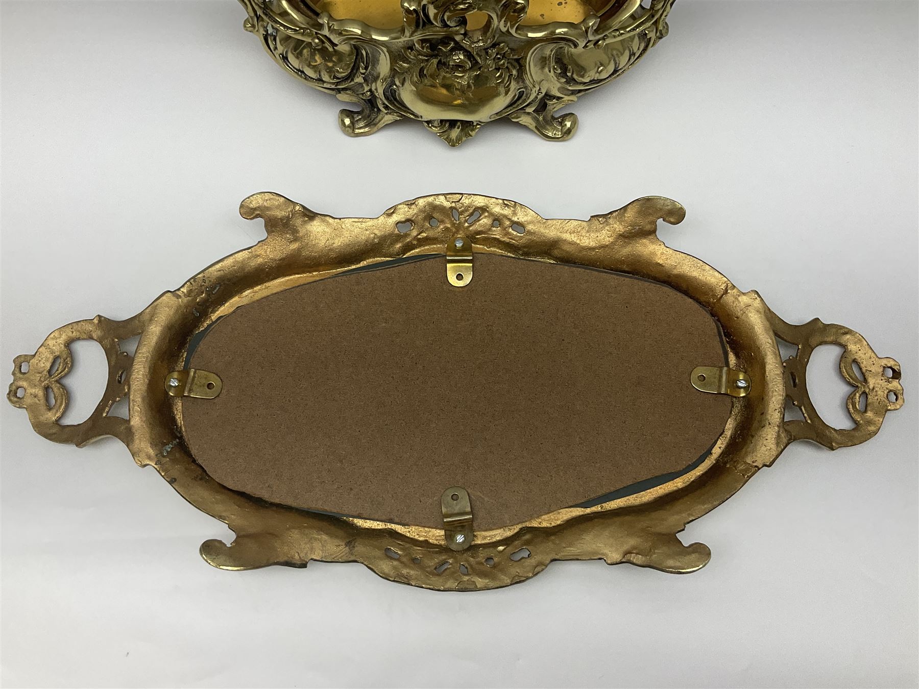 Ornate brass centrepiece, with twin handled vase upon a mirrored base, with floral and scrolling decoration, H23cm 