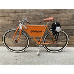 Fully restored vintage advertising bicycle with 2 stroke petrol engine, orange frame, tan leather seat