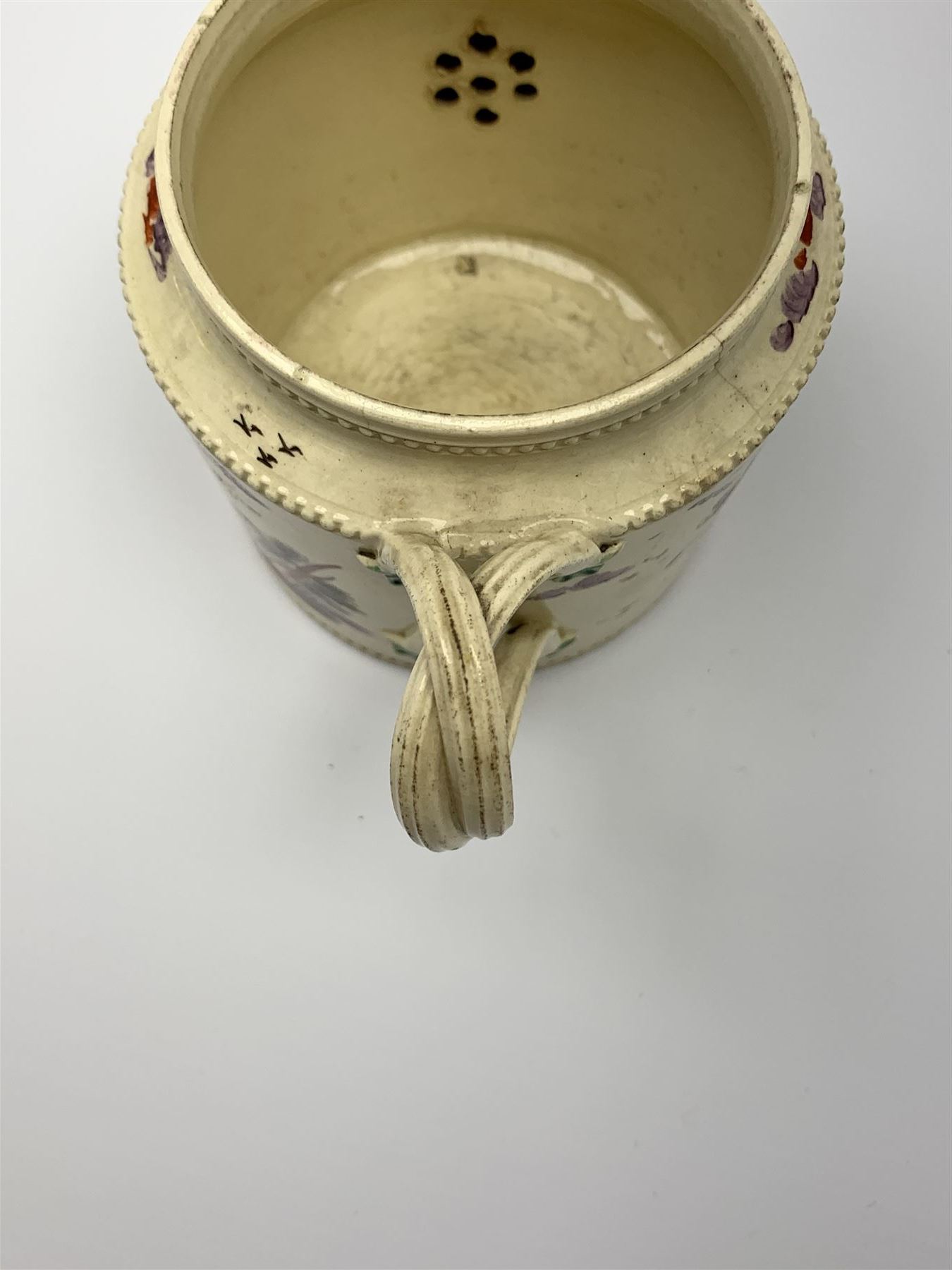 18th century creamware teapot, probably Leeds, with reeded entwined handle and floral finial to the cover, the body with hand painted polychrome decoration of figure to one side, and floral spray to the other, collectors paper label beneath inscribed Leeds Pottery, H11.5cm
