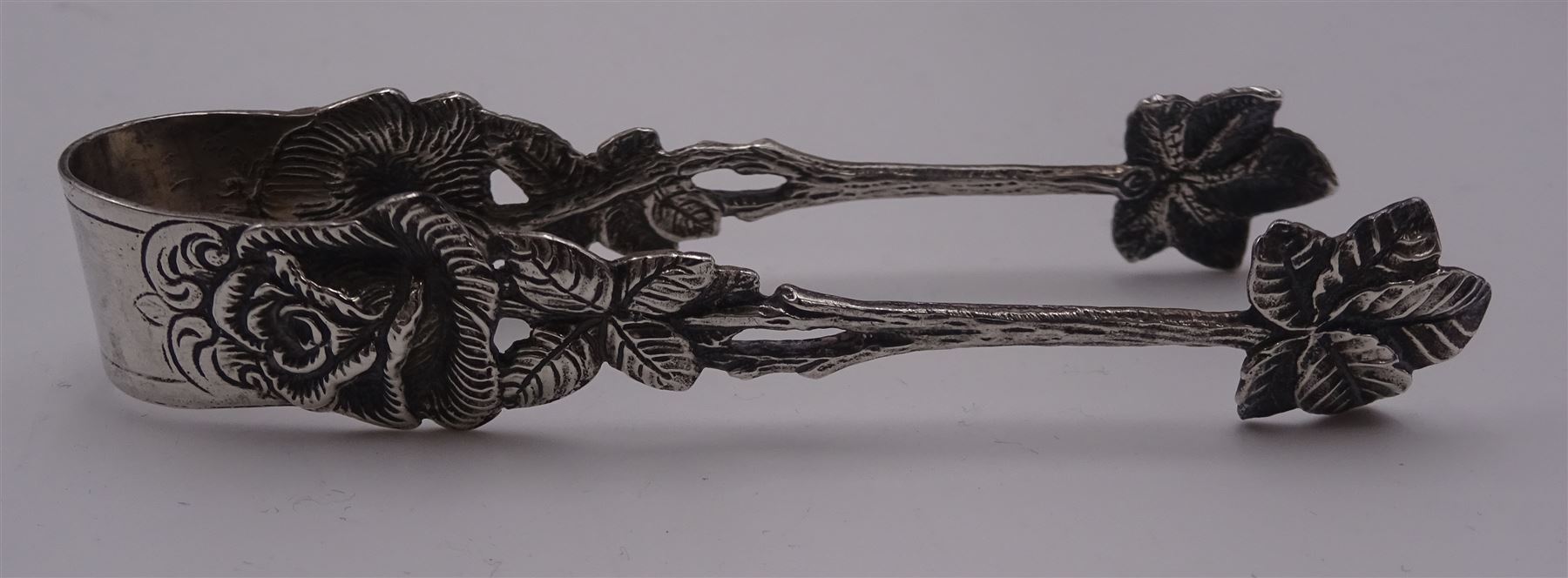 Group of silver flatware, to include Victorian christening set comprising knife, fork and spoon with silver handles, blade, prongs, and bowl, hallmarked Martin, Hall & Co, Sheffield 1868, William IV Fiddle pattern dessert fork, hallmarked William Eaton, London 1834, two Victorian teaspoons, 1920's teaspoons, and three Continental graduated spoons and set of matching sugar tongs with rose and vine detail, stamped 825, etc., together with a a small modern silver pendant modelled in the form of a heart, hallmarked Penhaligon's, Birmingham 1991, and two modern silver page markers, each stamped 925, one example worn import mark, approximate total weight 8.61 ozt (267.8 grams)