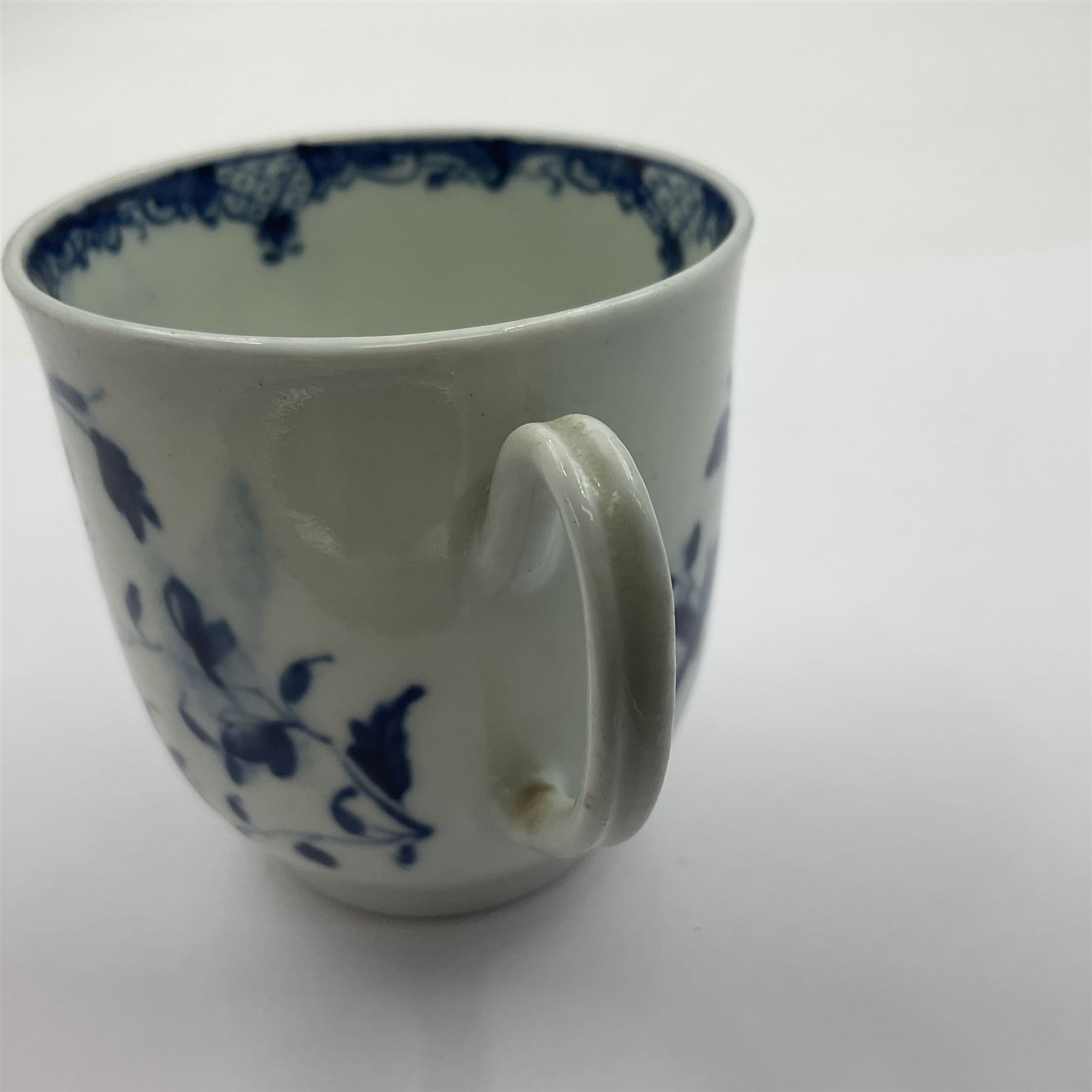 Two 18th century Worcester porcelain coffee cups, the first example decorated in the Plantation pattern, circa 1754, the second decorated in the Mansfield pattern, circa 1760, with workman's mark beneath, each approximately H5.5cm
