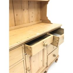 Waxed pine dresser with plate stand, projecting cornice, two shelves above six short drawers, dresser is complete with 6 short drawers and single opening cupboard, turned supports 
