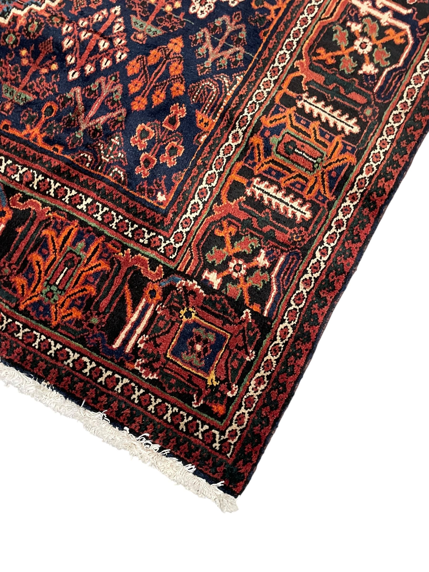 Persian Joshaghan red ground rug, stepped lozenge medallion surrounded by small lozenge motifs, the border decorated with stylised plant motifs within patterned guard stripes