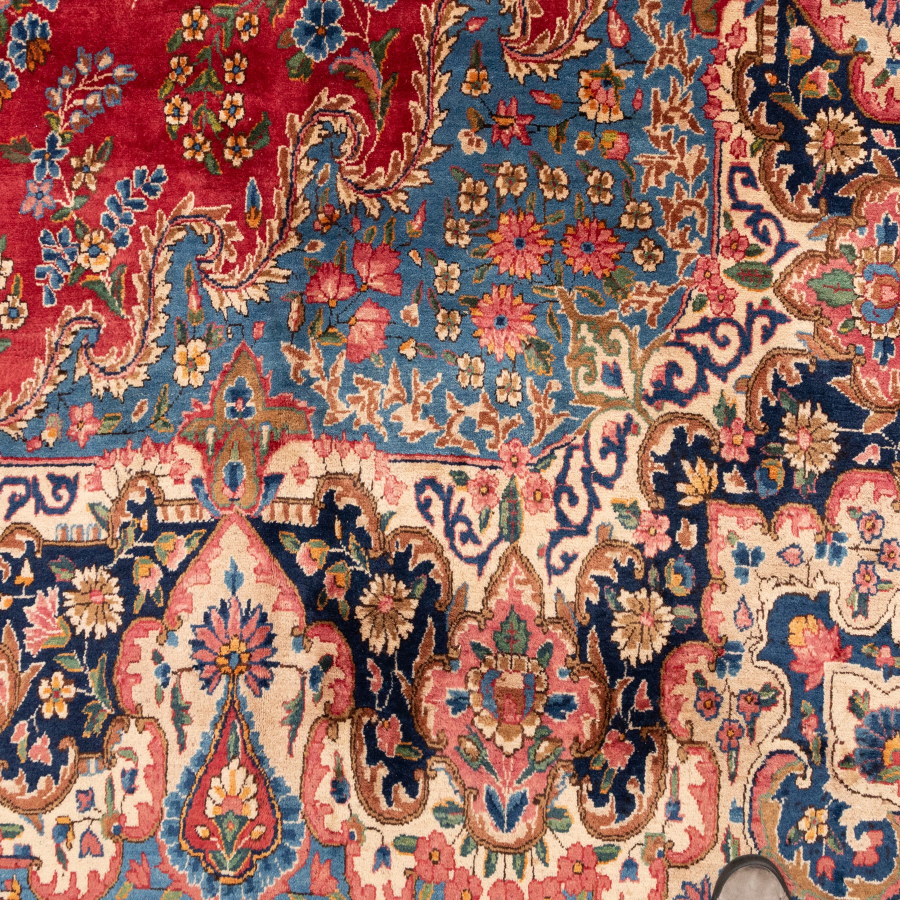 Fine Persian crimson ground Kashan carpet, the busy field with a central floral pole medallion surrounded by bouquets of flowerheads and trailing foliage, the shaped cyan spandrels similarly woven, enclosed by a wide foliate guard band of stylised palmettes and floral designs
