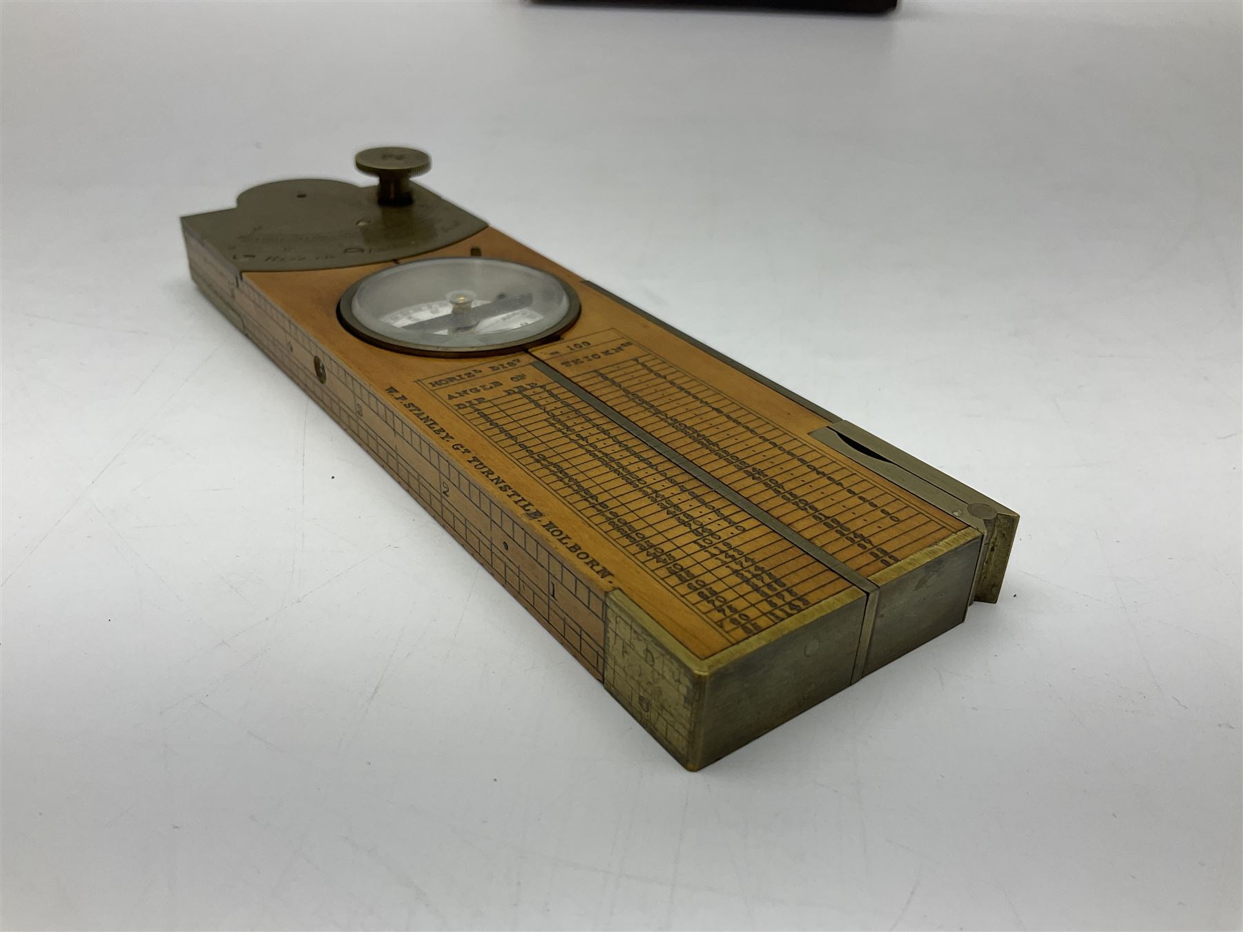 Late 19th/early 20th century boxwood and brass clinometer rule by Stanley, with inset magnetic compass, screw action protractor hinge divided to one degree with rise in inches per yard scale under, spirit level to one edge, marked 'W.F. Stanley Great Turnstile Holborn' with tables of distances, angles and thickness H16cm closed: in original leather covered case with instructions