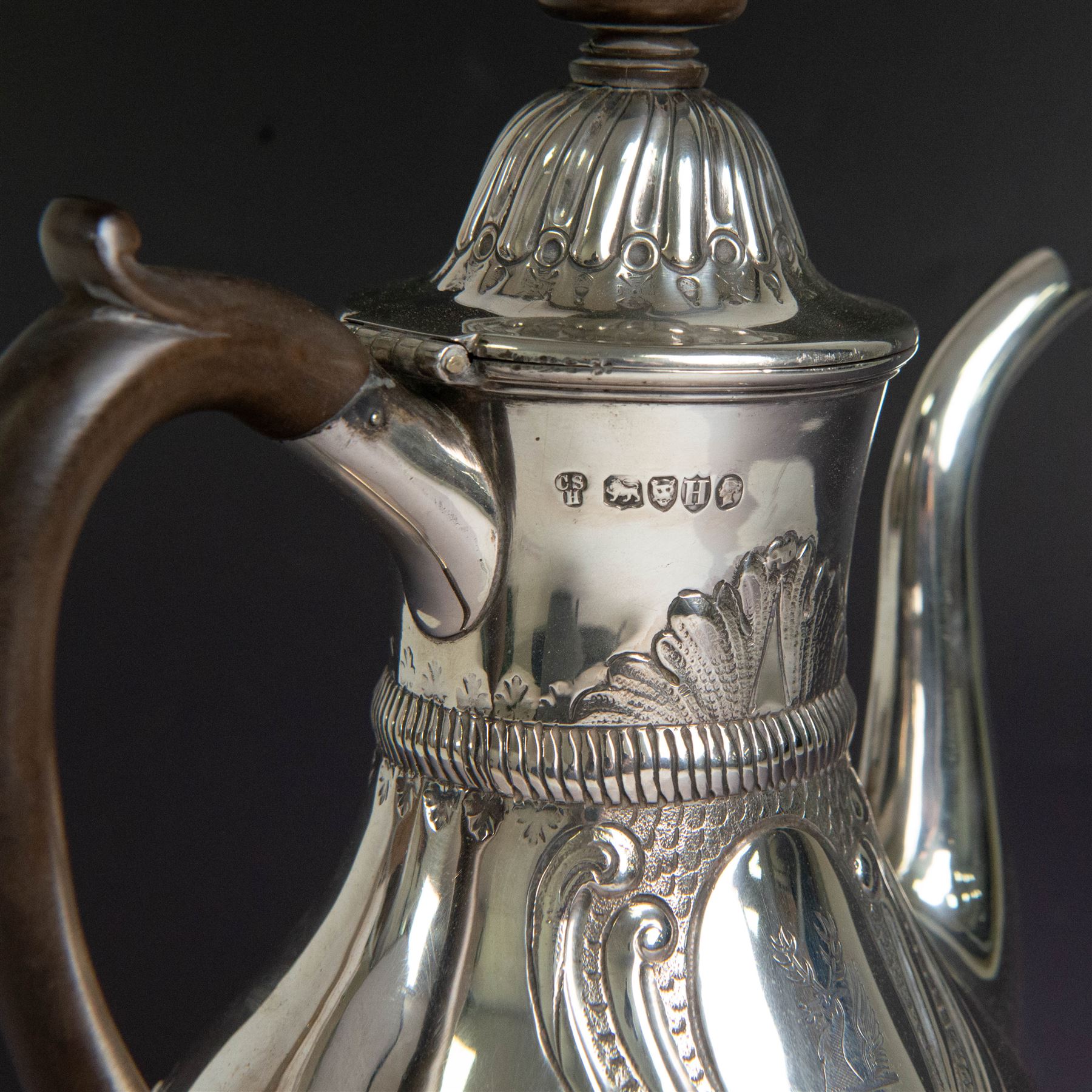 Victorian silver coffee pot, of part fluted baluster form, with central oval cartouche engraved with peryton crest, bordered by C scrolls and chased scales, with impressed acorns, stars and leaves throughout, with wooden handle and finial to domed hinged cover, hallmarked Charles Stuart Harris, London 1883, H23cm