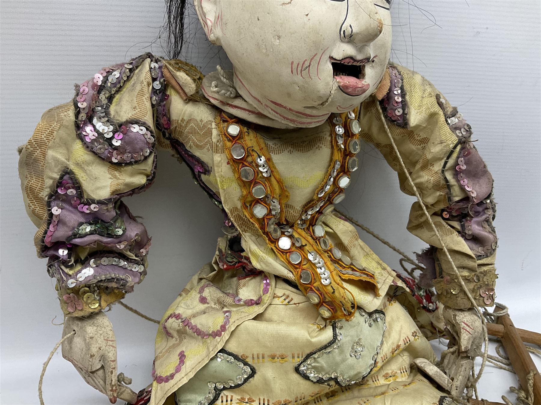Large string puppet, probably Thai or Burmese, modelled as a woman in traditional costume embellished with sequins, the painted head with articulated mouth, the wood body and hands jointed, L70cm