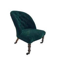 Small Victorian walnut framed nursing chair, spoon back upholstered in buttoned green fabric, on turned front supports, brass cups and castors