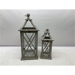 Two wooden lanterns with four glass sides, loop handles and open tops, largest example 58cm