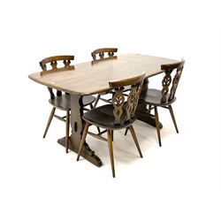 Ercol Beamish refectory rectangular dining table, two shaped supports with sledge feet, joined by moulded stretcher (L153cm, D76cm, H71cm) and four Windsor chairs featuring shaped splat and turned supports (W42cm)