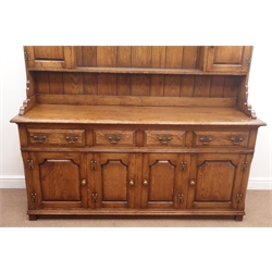  17th century style medium oak dresser, projecting cornice, dentil frieze, two plate shelves with two cupboards above four drawers and four cupboards, stile supports, W181cm, H198cm, D49cm  