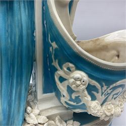 Rare 19th century Minton turquoise glaze majolica 'The Reader' flower holder, after Albert Carrier-Belleuse, modeled as a maiden in classical drapery reading whilst leaning against the pillar back of the helmet shaped cistern detailed with a caryatid and floral swags, the whole upon an oval plinth with Greek key border, with impressed marks beneath, H44cm