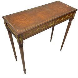 Early 20th century mahogany side table, inset amber leather surface, frieze decorated with applied gilt festoons and central wreath, on tapering fluted supports