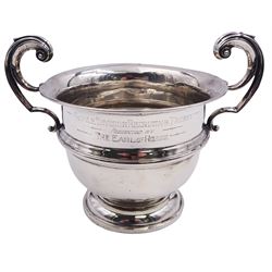 20th century silver twin handled trophy cup, the body with central girdle, personal engraving and twin flying scroll handles, upon a spreading circular foot, hallmarked Birmingham, makers mark and date letter worn and indistinct, including handles H15.5cm D15cm, approximate weight 9.43 ozt (293.6 grams)