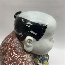 Japanese Fukusuke good fortune figure, modelled as a kneeling male figure holding a fan, dressed in traditional Samurai robes, H15.5cm