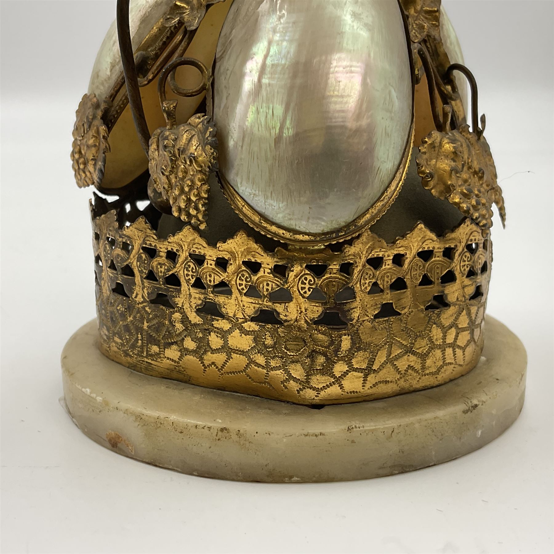 Victorian evening dinner bell, with three mother of pearl shells, floral and grape gilt decoration, and bird finial, raised upon a circular soapstone base with gilt pierced gallery, H14cm
