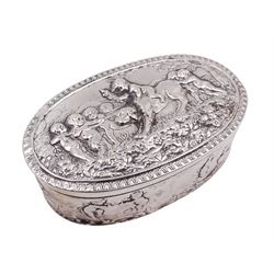 Late 19th century German Hanau silver box, of oval form, embossed throughout with putti in various scenes including riding a dog, playing instruments, pulling a cart and dancing, opening to reveal a gilt interior, with Hanau marks for B Neresheimer & Sohne, W9cm, H3cm