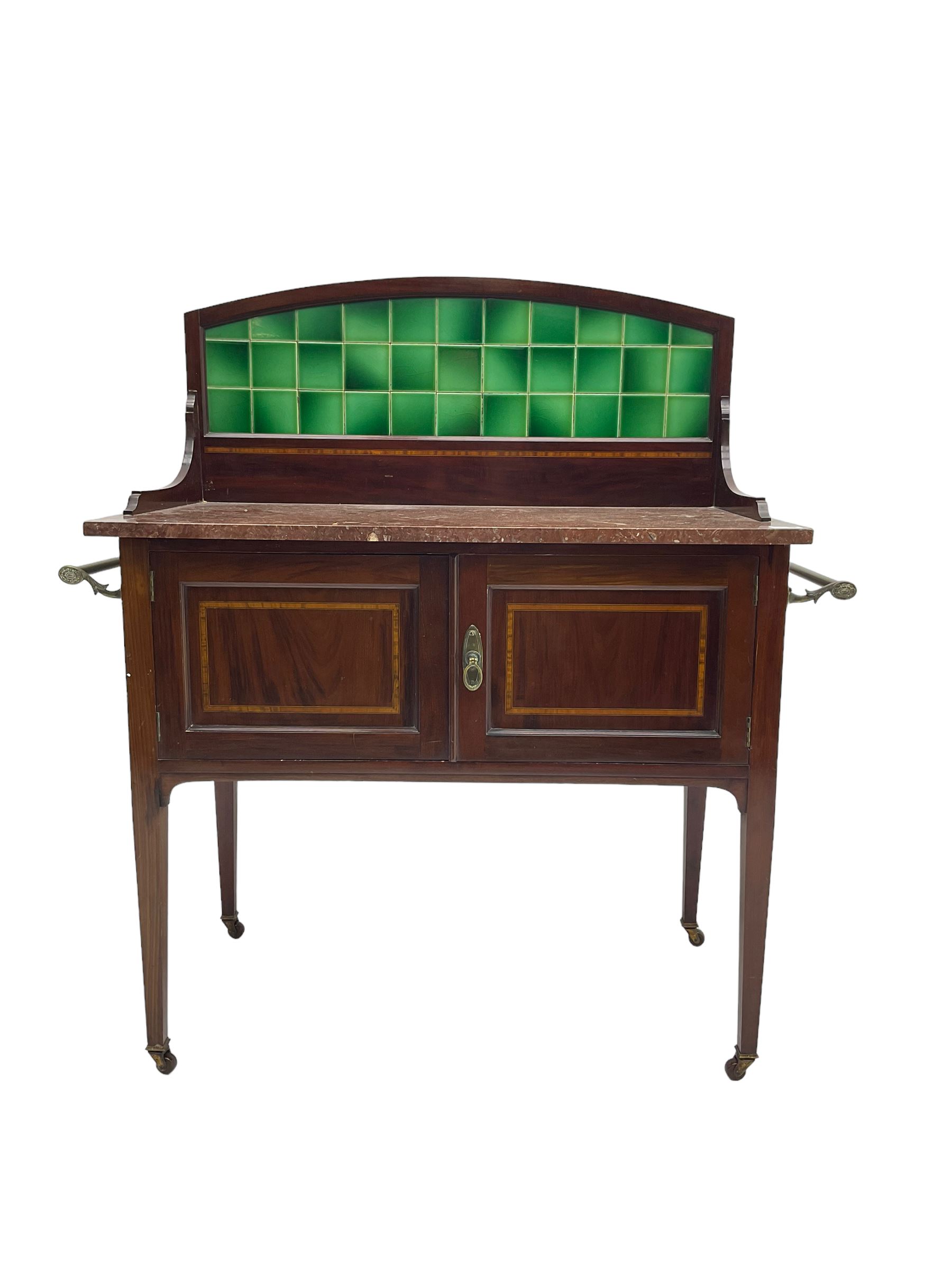 Edwardian inlaid mahogany washstand, raised back with emerald green tiles over marble top, fitted with two panelled cupboard doors, raised on square tapering supports on ceramic castors