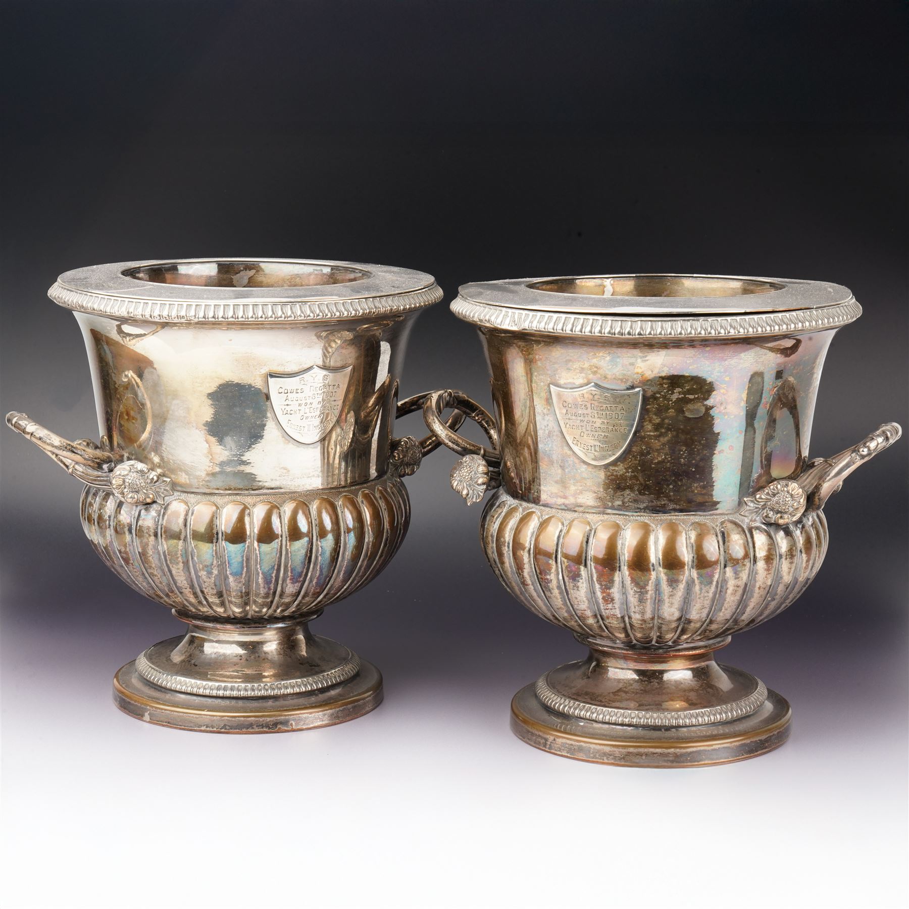 Pair of Edwardian silver plated wine coolers of campana form with twin handles and shield shape cartouches, inscribed 'Cowes Regatta 1907' H23cm