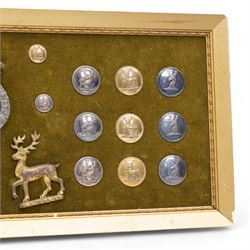 Collection of twenty two 19th century livery buttons with stag motif, badge with stag and St George design and two gilt stag  badges, framed 18cm x 44cm 