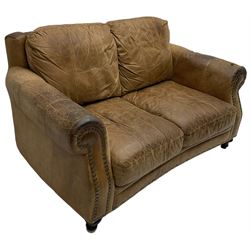 Two-seat club sofa, rolled arms upholstered in tan leather with stud work bands, on turned feet 