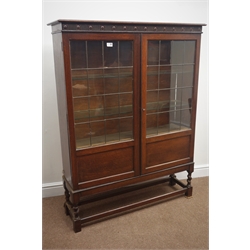  Early 20th century oak bookcase, carved frieze, two lead glazed doors enclosing three shelves, barley twist supports joined by stretchers (W107cm, H140cm, D31cm), and an oak drop leaf table  