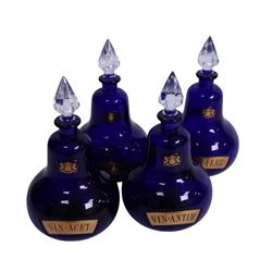 Set of four 20th century Royal Pharmaceutical Society blue glass bottles, of bellied form with clear cut glass spire stopper, each body bearing gilt label in Latin: VIN:ACET:, VIN:ANTIM:, VIN:XERIC:, and VIN:FERR:, and gilt Royal Pharmaceutical Society crest to neck, H25cm

Provenance: From the collection of the family of Peter Green, a practising pharmacist whose career spanned the mid to late 20th century. During his professional life he managed pharmacies in Yeovil, Somerset, and later Selles Chemist in Filey, North Yorkshire, before purchasing and running his own business, Peter Green Pharmacy, located in the Market Place, Malton. The bottles were displayed as part of the traditional shop fittings in both the Filey and Malton pharmacies and were retained as part of his collection.