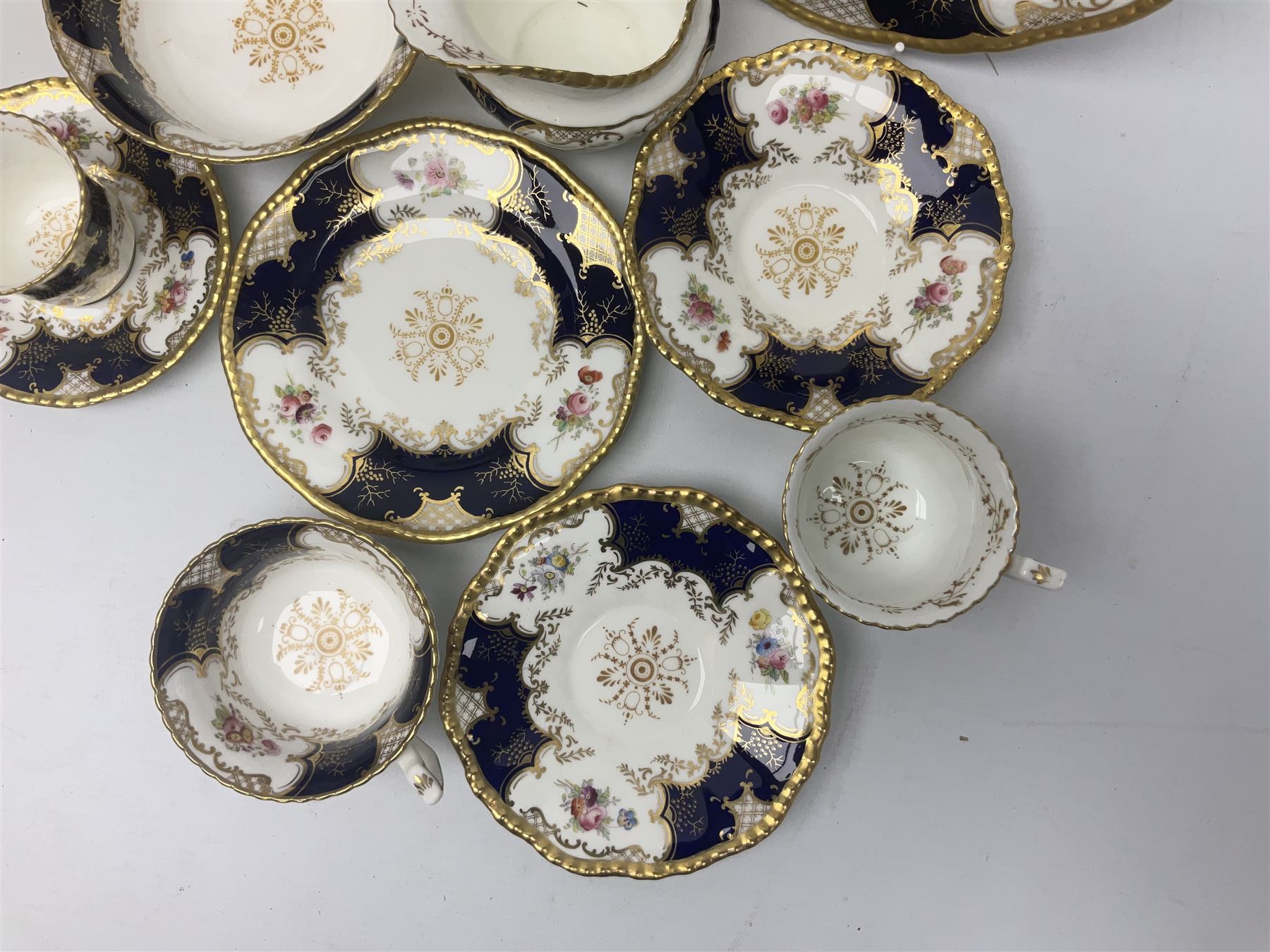 Coalport cobalt blue batwing pattern tea wares, decorated with finely enamelled floral sprays within gilt reserves, comprising teacup trio, coffee can and saucer and other cup and saucer, twin handled cake plate, milk jug and open sucrier, and circular plate retailed by T. Goode & Co London, pattern no Y2665,  all with green Coalport AD 1750 marks beneath, largest W26cm (11)