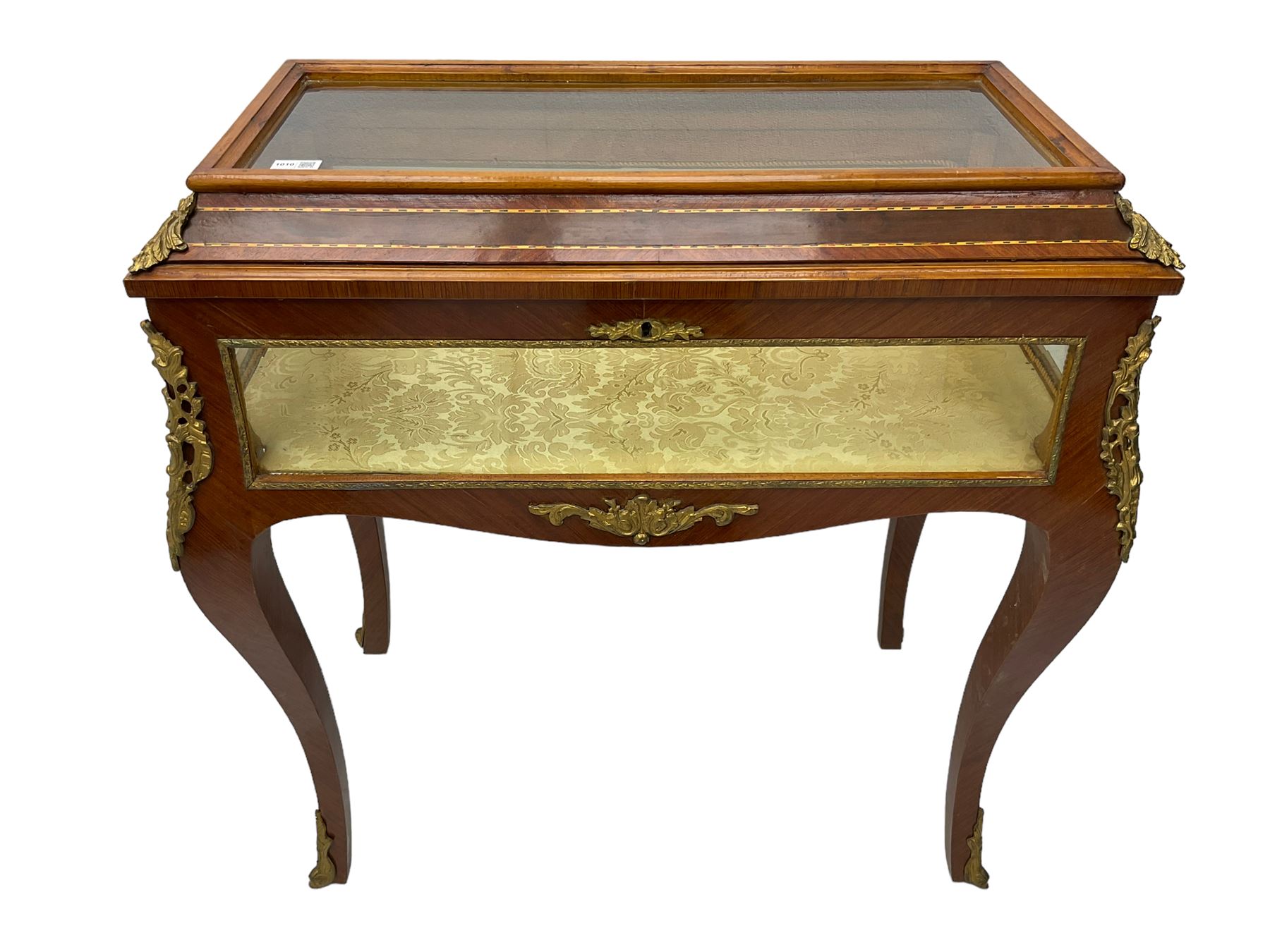 Mid-to-late 20th century French design Kingwood and walnut bijouterie cabinet, enclosed by cavetto moulded hinged lid with gilt metal foliage cast mounts and checkered stringing, on cabriole supports mounted by ornate cartouche castings and scrolled foliate terminal caps, lined in gold foliate pattern fabric and glazed with bevelled glass