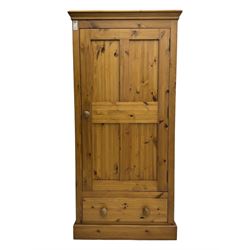 Pine single wardrobe, enclosed by single panelled door, fitted with single drawer, on plinth base 