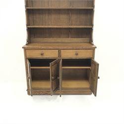  Medium oak dresser with two tier plate rack, two drawers above four cupboard doors, panelled sides, W121cm, H182cm, D48cm  