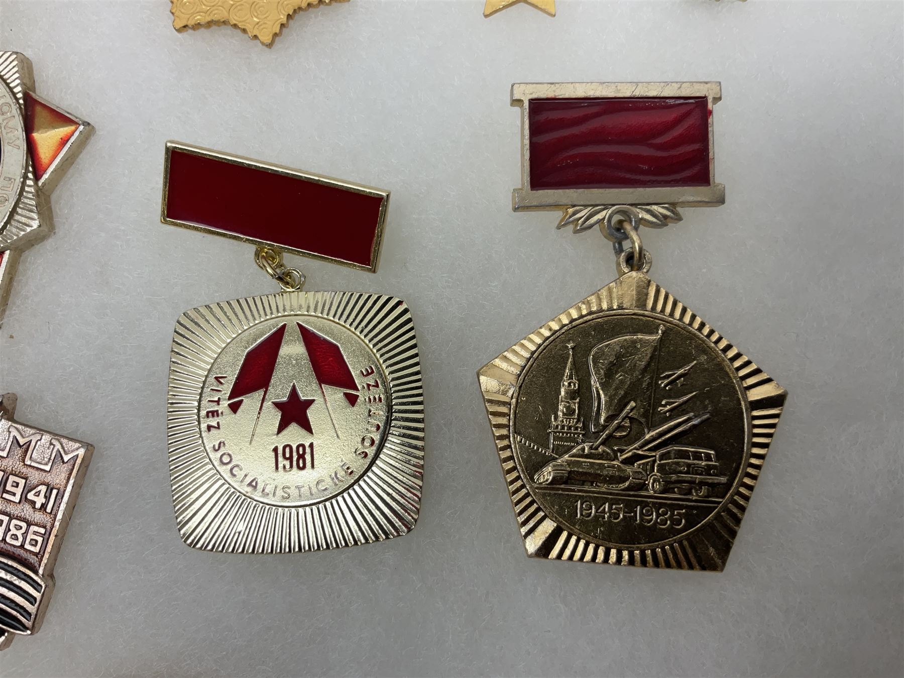 Nineteen Russian Soviet Tank Commemoration badges and medals, in small display case