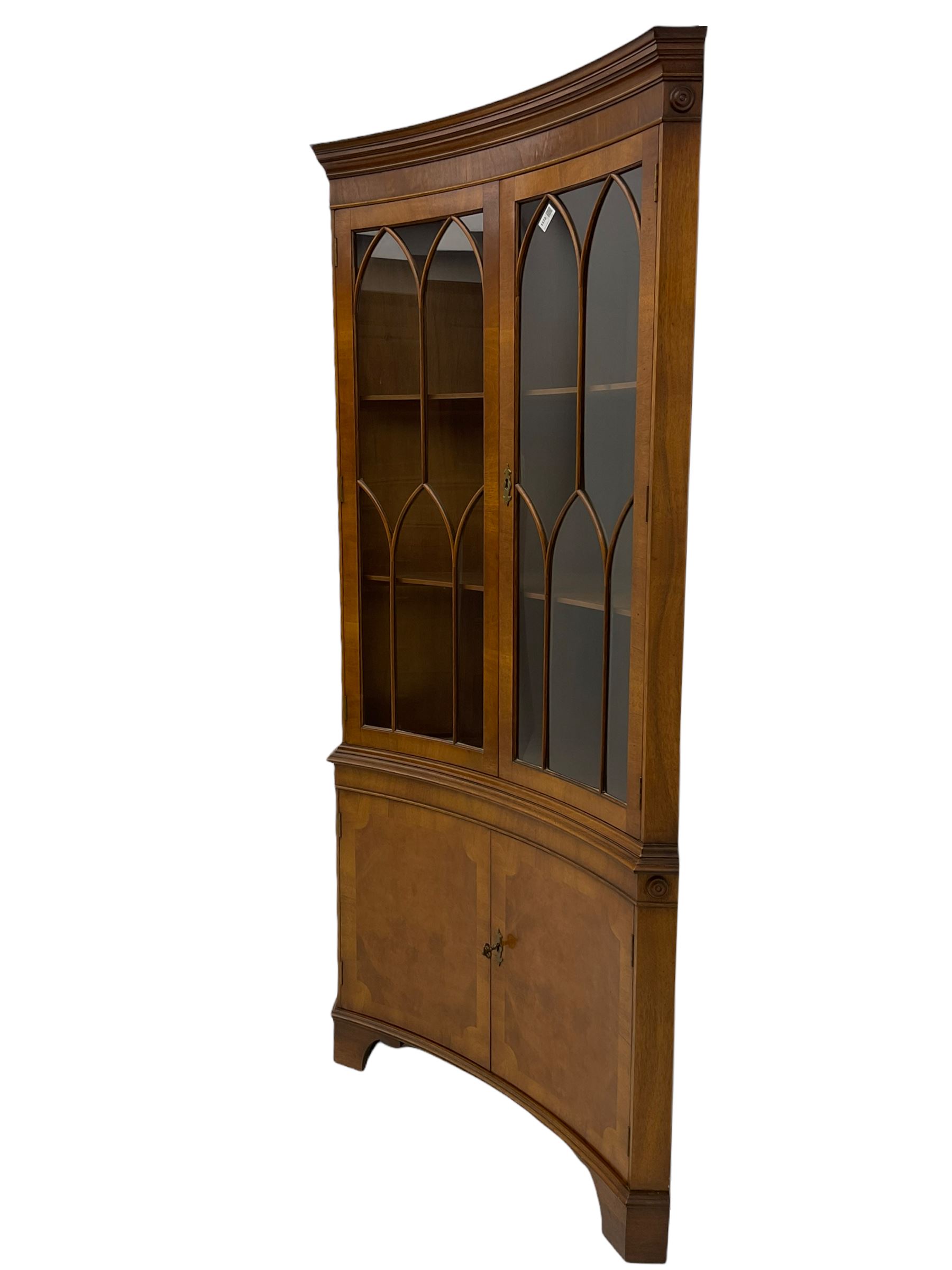 Late 20th century Georgian design mahogany concave corner display cabinet, enclosed by two curved astragal glazed doors, double cupboard below, on bracket feet