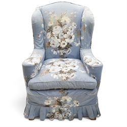 Pair of Queen Anne wingback armchairs, high back over out-swept arms, raised on ball-and-claw feet, upholstered in sky-blue ground floral chintz loose upholstery with pleated skirt and squab cushion
