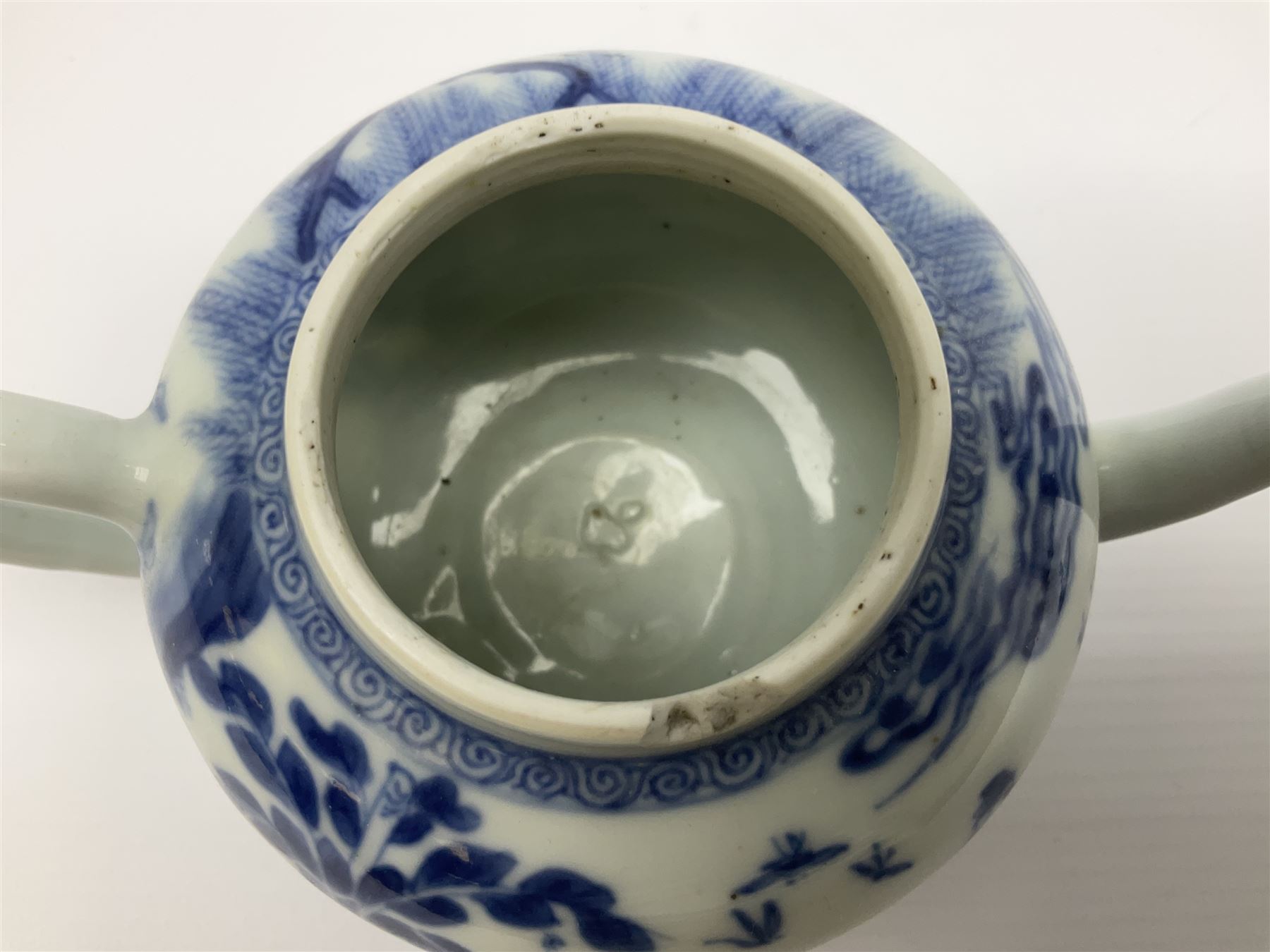 Two late 18th/early 19th century Chinese export teapots, the largest example of globular form with curved handle and straight spout, decorated in the Mandarin style with figural scenes surrounded by red scale reserves, H13.5cm, the second smaller example decorated in underglaze blue with two musicians in a landscape set with willow tree and fence, H10.5cm

