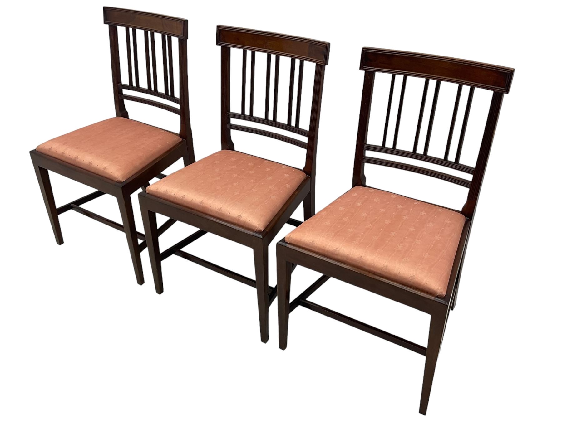 Early 20th century Regency design mahogany tilt-top table, circular top with edge banding, supported by a central turned pedestal with four reeded sabre supports terminating in castors; six chairs with pink upholstered drop in seats (7)