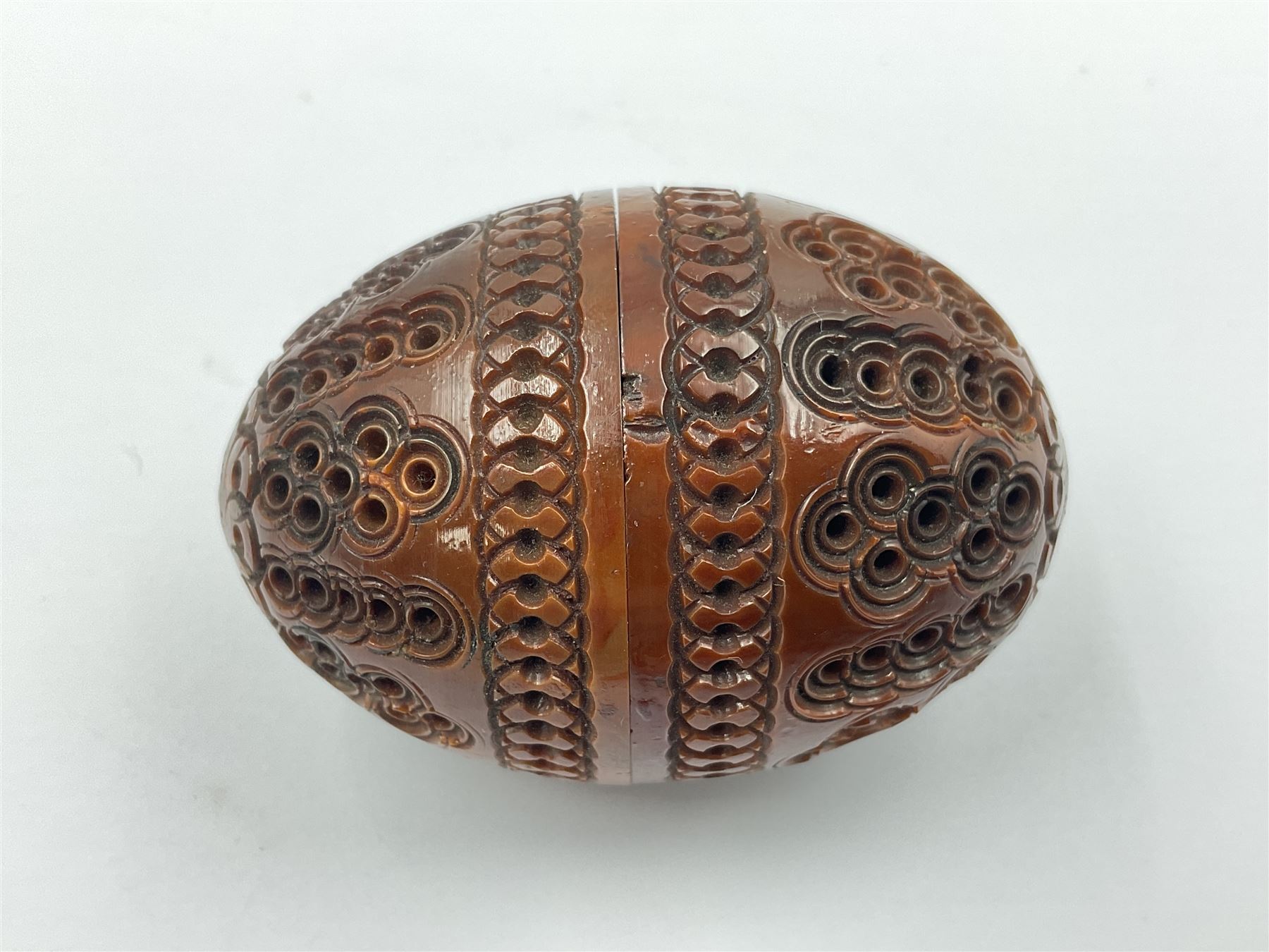 Three 19th century coquilla nut pomanders or flea catchers, two of egg shaped form and the third of barrel from with carved and pierced decoration and screw threaded join, largest H8cm