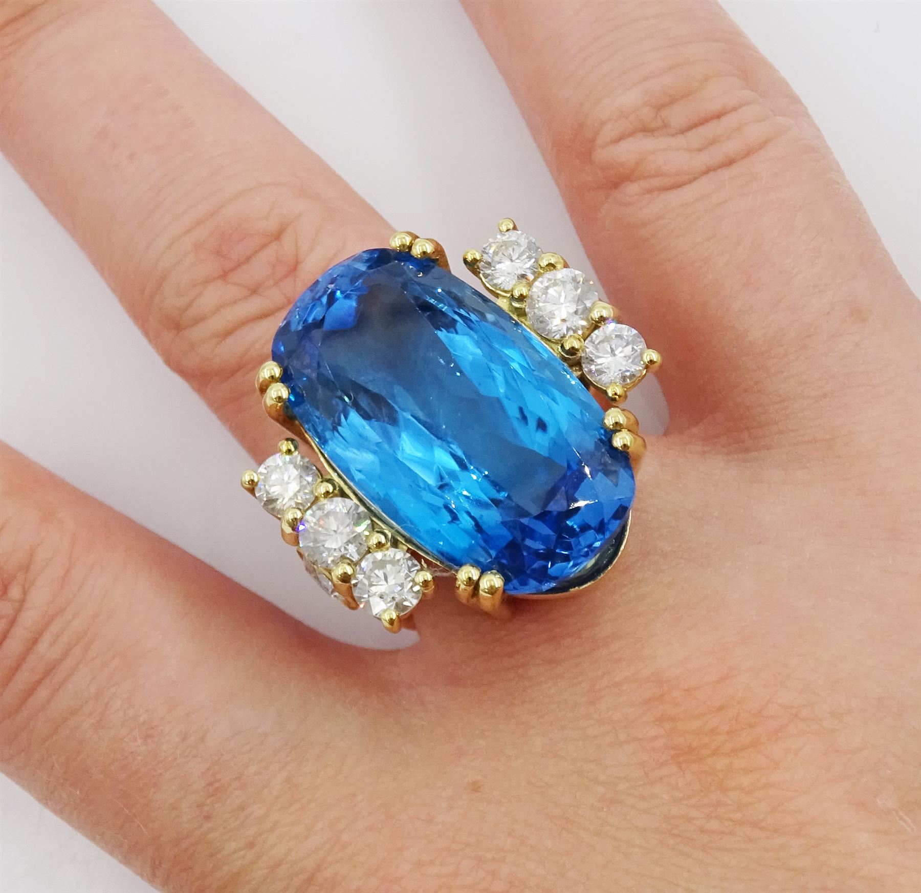 18ct gold blue topaz and diamond ring, single oval cut blue topaz of approx 31.10 carat, with four round brilliant cut diamonds set either side and a further two diamond set to the gallery, London 2019, total diamond weight approx 2.25 carat