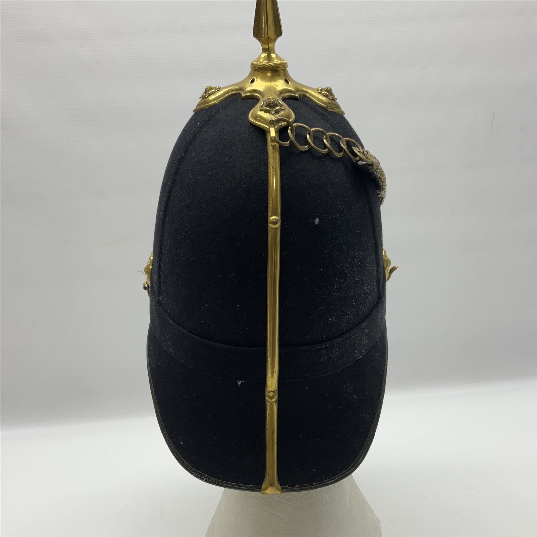 Late Victorian North Staffordshire Regiment Officer's Home Service Blue Cloth Helmet, having incorrect other ranks gilt metal Queen's crown helmet plate to the front with later leather backing, removable spike to the top on a shaped cruciform base with rosette fittings, rosette side bosses, brass trim to the front peak, and leather and velvet backed chin scales, with leather sweat band, the interior with makers stamp for Hawkes & Co 14 Piccadilly London